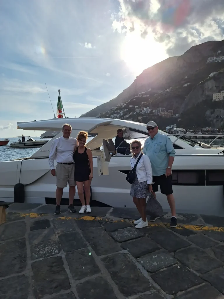 Group of people in front of a yacht at sunset on the Amalfi Coast