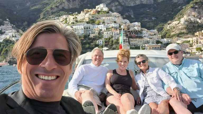 Two couples of tourists in a private boat tour, enjoing Amalfi coast and the Bay of Naples from the sea