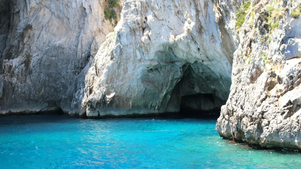 Exterior view of the Blue Grotto, showing the rocky cliffs and the turquoise water below