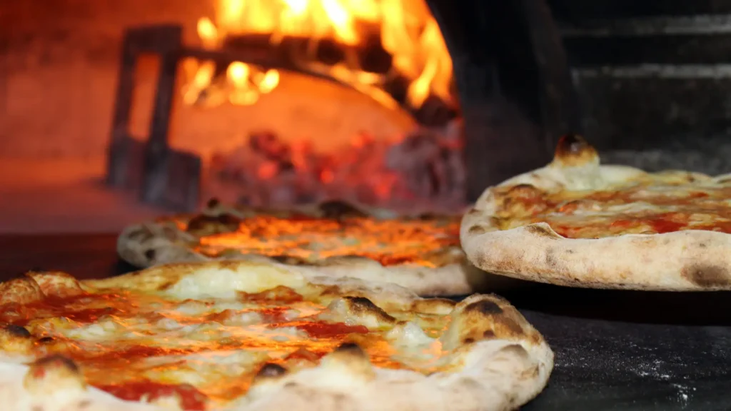 Freshly baked foldable pizza in a traditional wood-fired oven in Naples