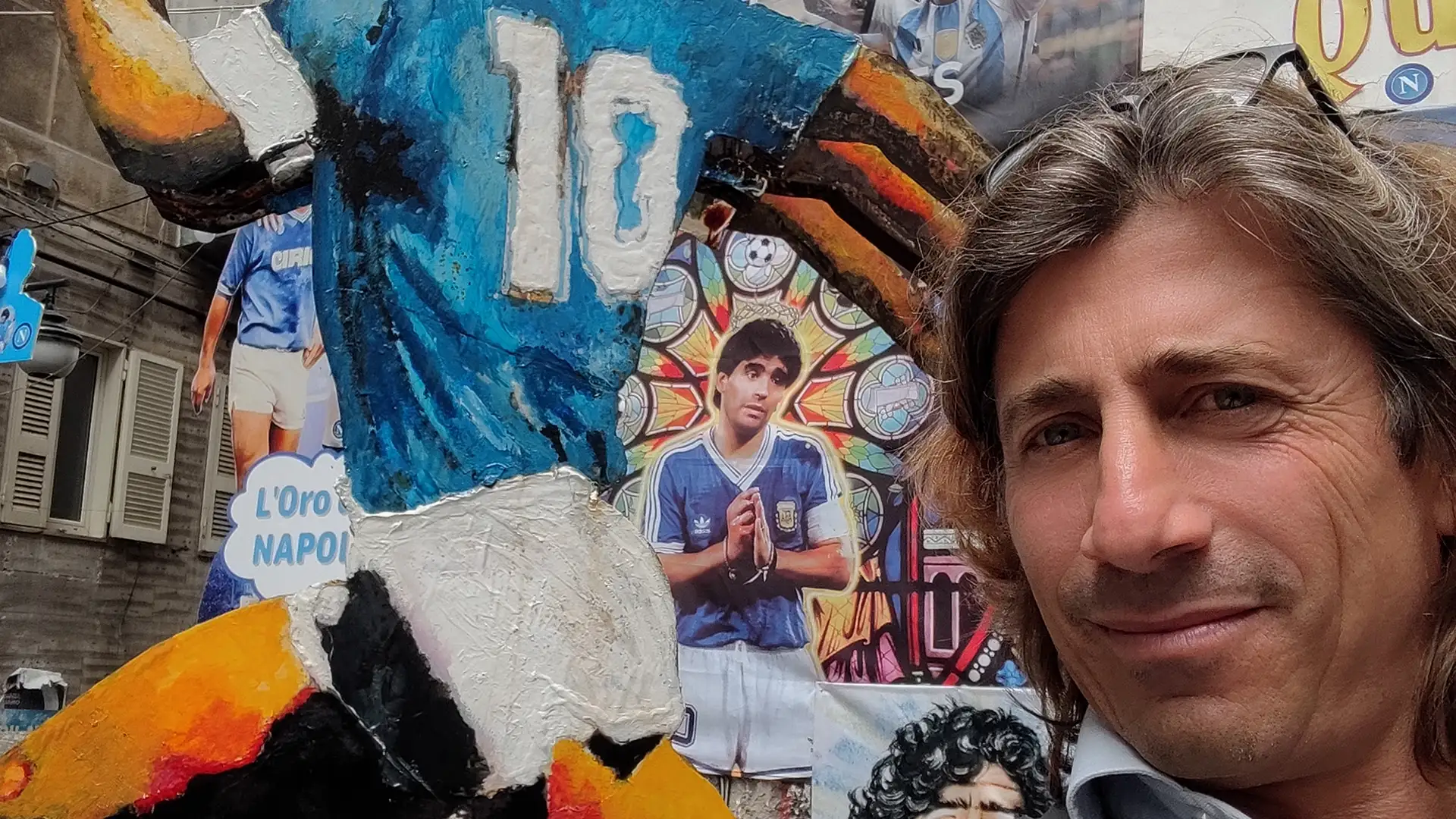 Luca next to a mural dedicated to Diego Armando Maradona in Naples